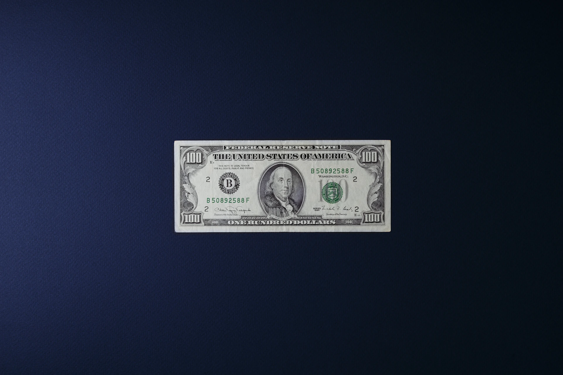 a one dollar bill sitting on top of a blue surface