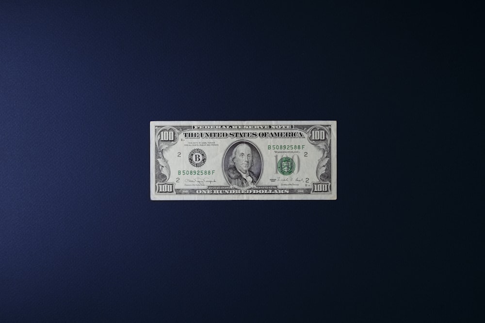 a one dollar bill sitting on top of a blue surface