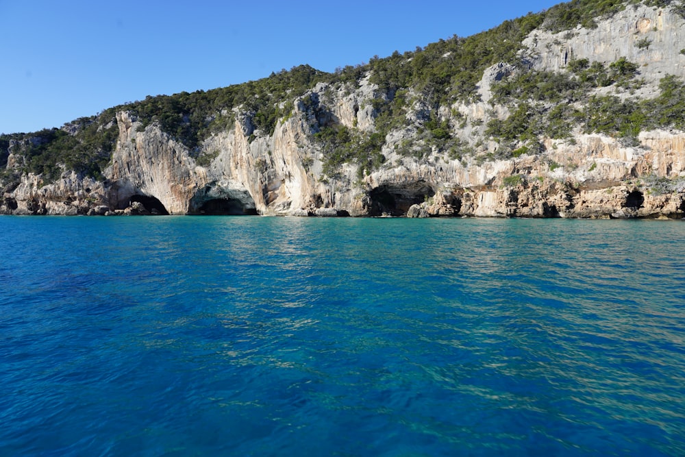 a large body of water near a rocky cliff