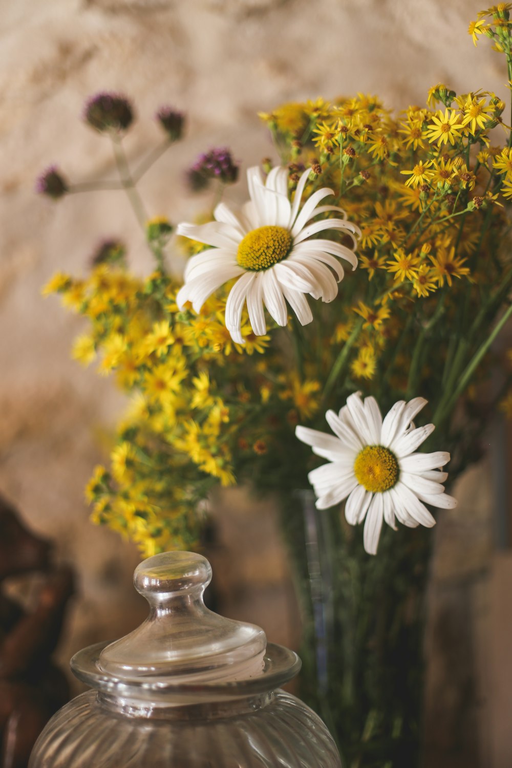 a vase filled with yellow and white flowers