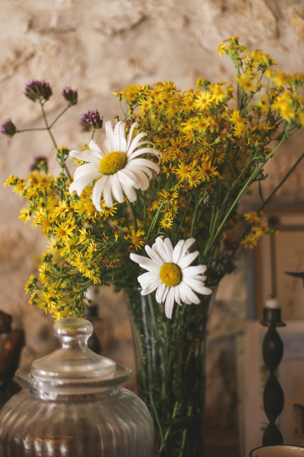 un vase rempli de fleurs jaunes et blanches