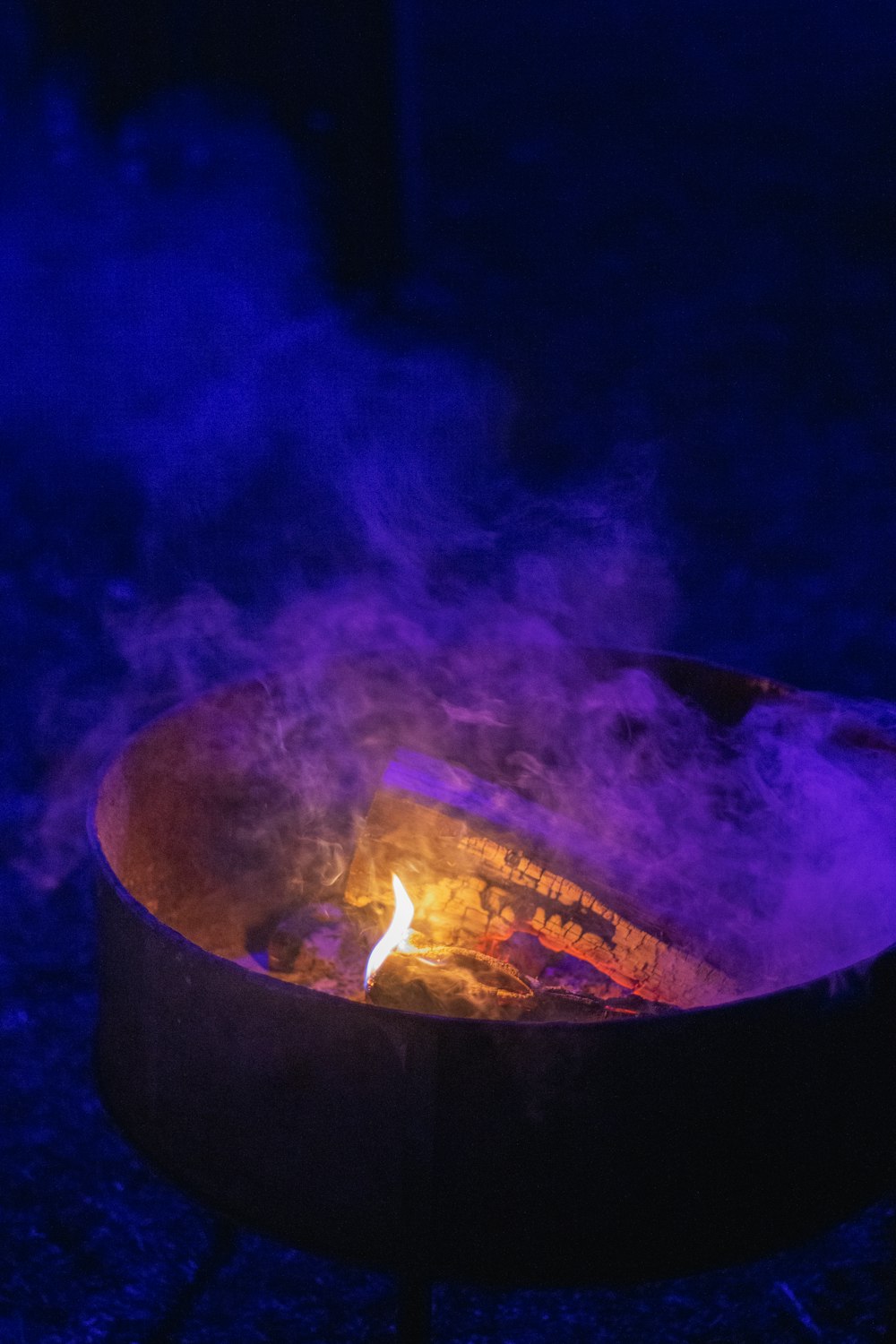 a fire pit with purple smoke coming out of it