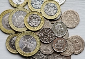 a pile of british coins sitting on top of a table
