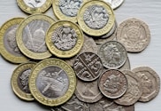 a pile of british coins sitting on top of a table