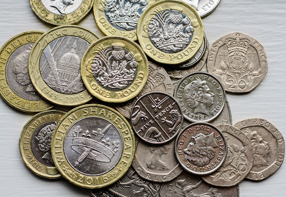 a pile of british coins sitting on top of a table