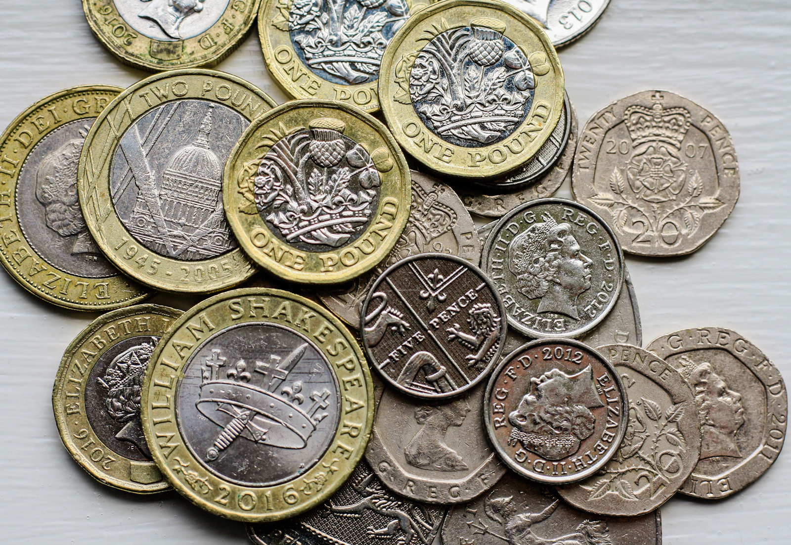 A pile of British pound coins on a table