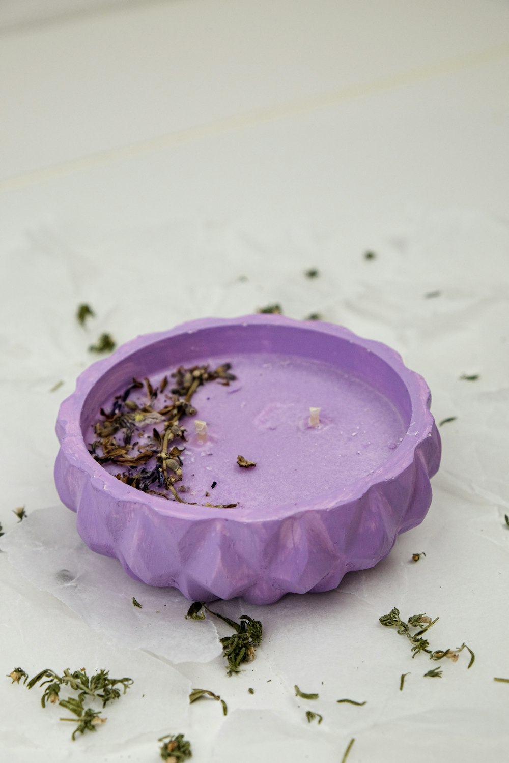 a purple bowl filled with herbs on top of a table