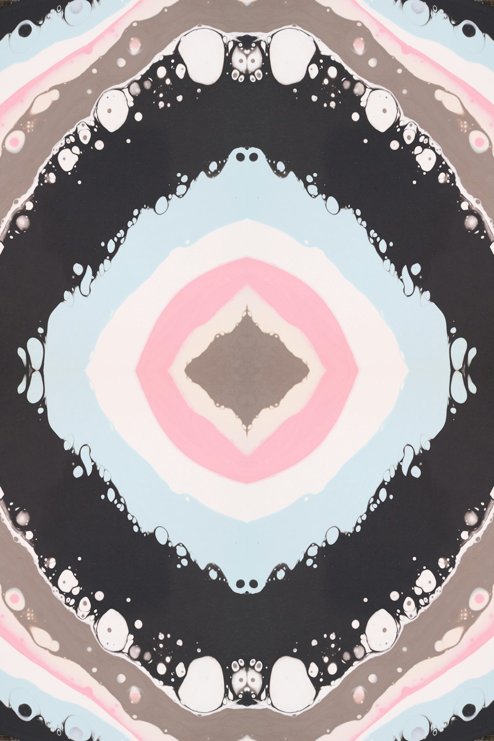 a circular painting with a black, white, pink, and blue design