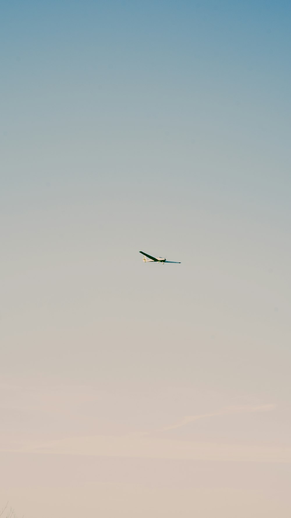 an airplane is flying in the sky above a field