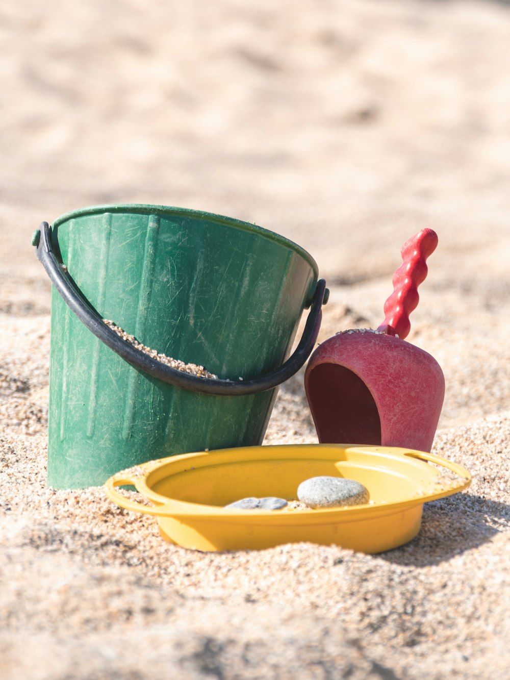a bucket and shovel sitting in the sand