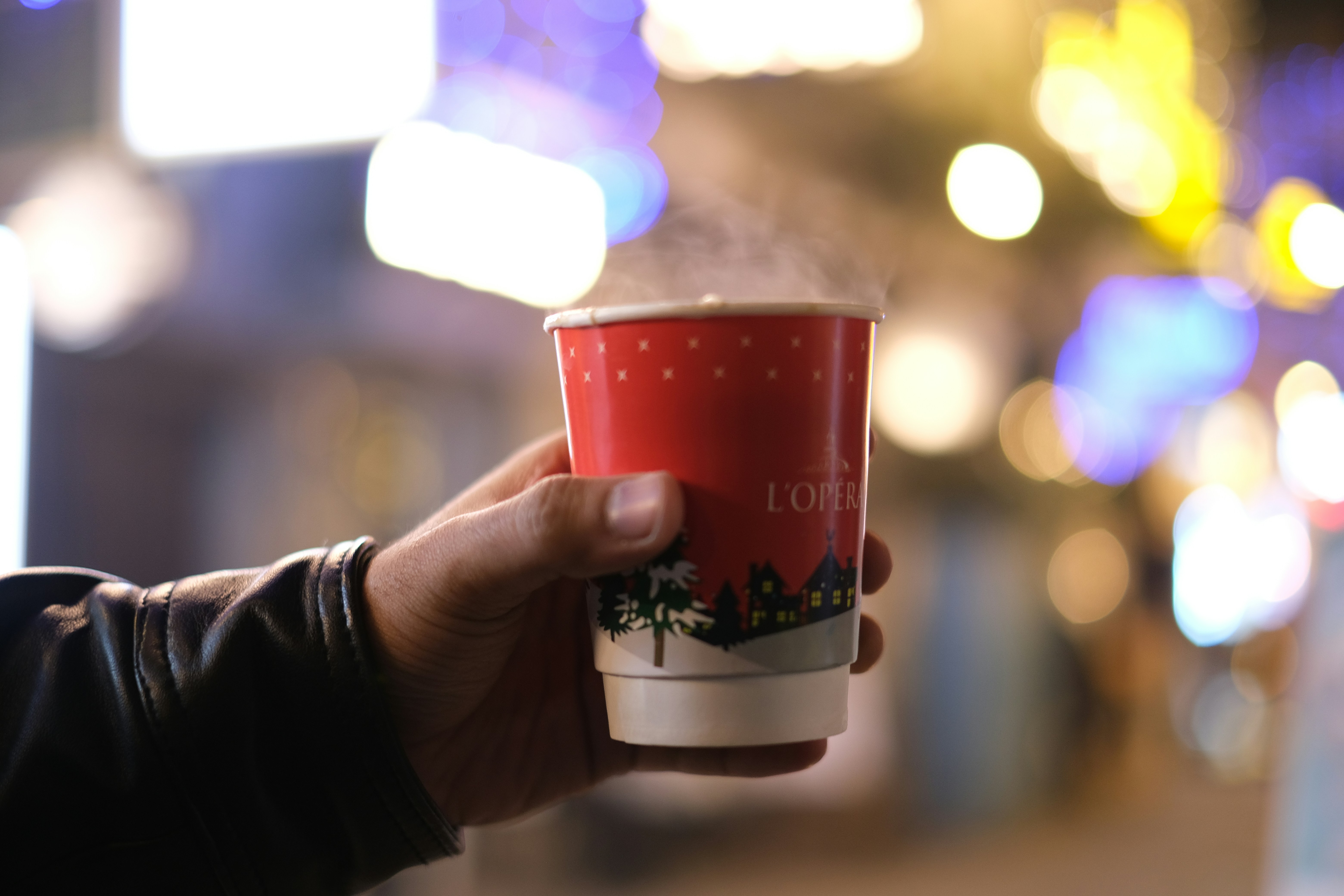 a person holding a cup of coffee in their hand, 