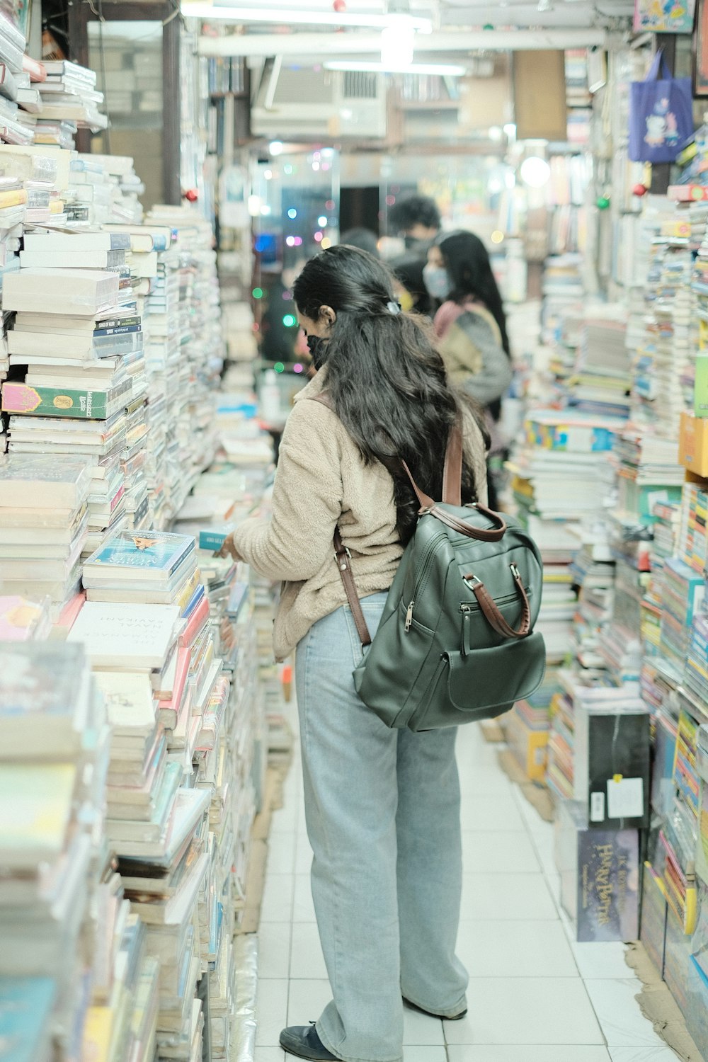 a woman is looking at books in a book store