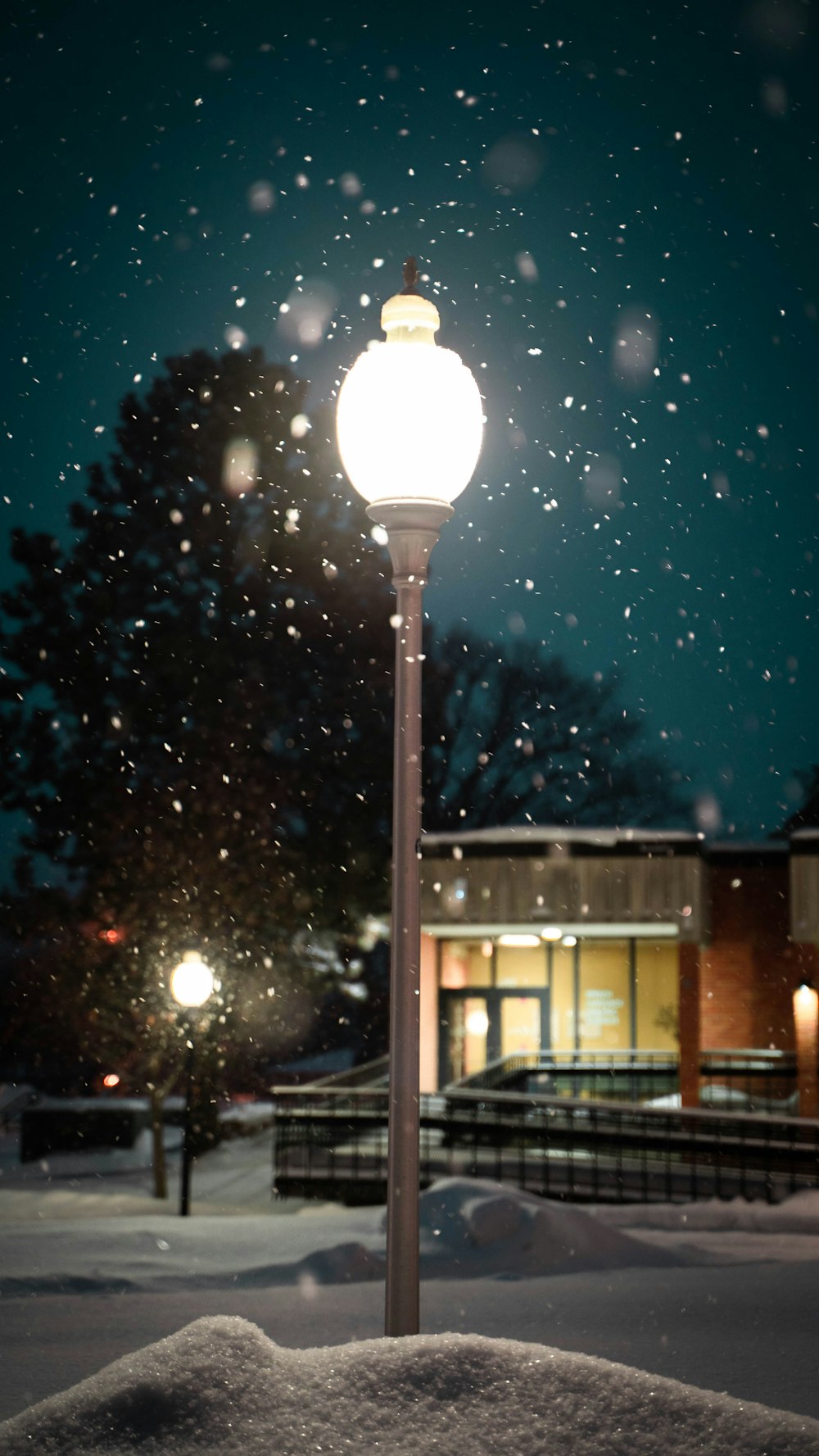 a street light in the middle of a snowy night