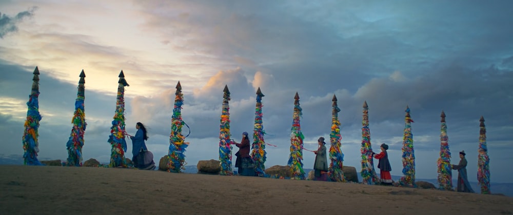 a group of people standing on top of a sandy beach