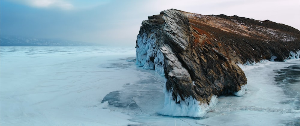 an ice covered rock sticking out of the water