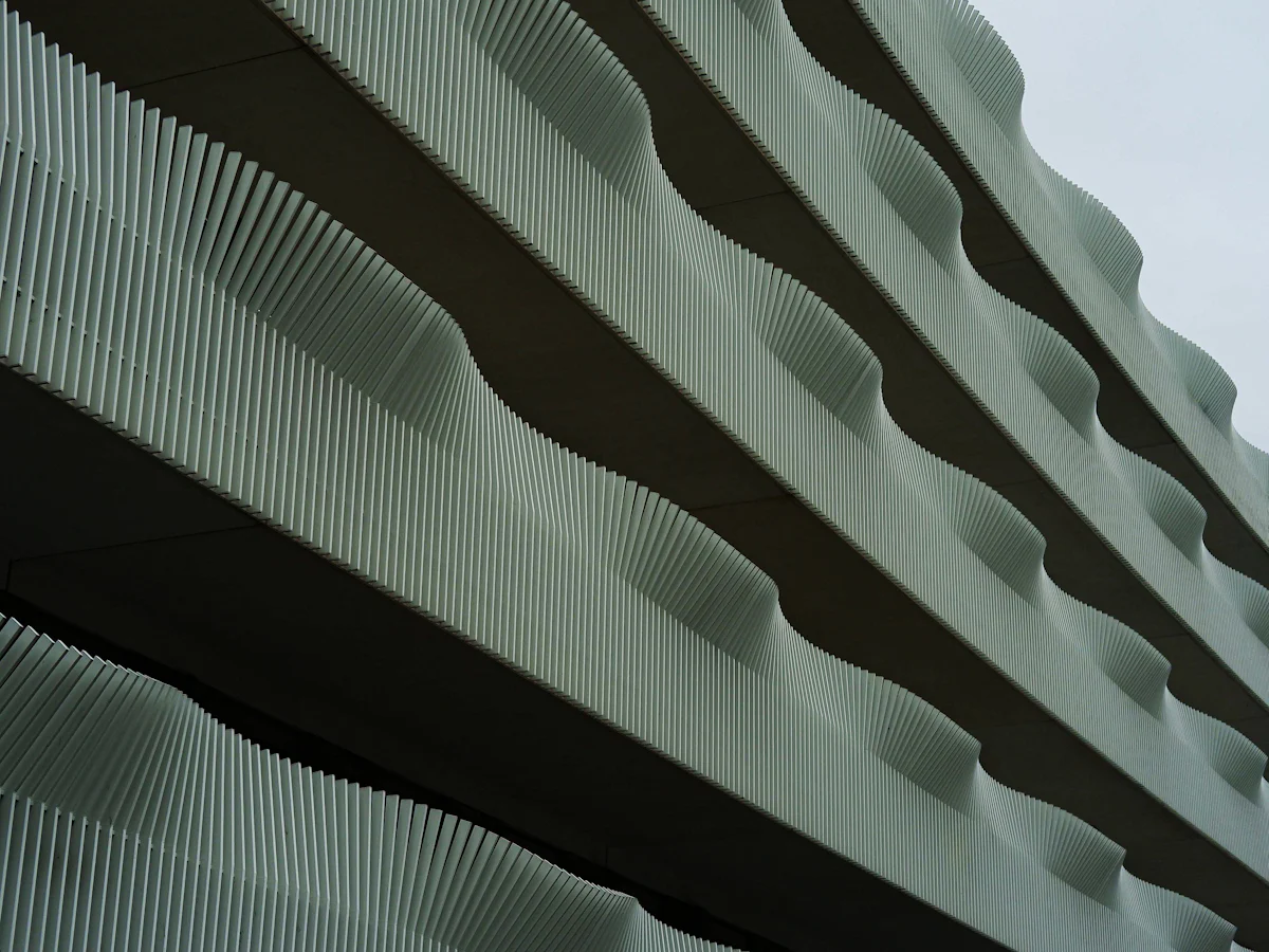 Corrugated aluminium façade with deep vertical ribs catching daylight