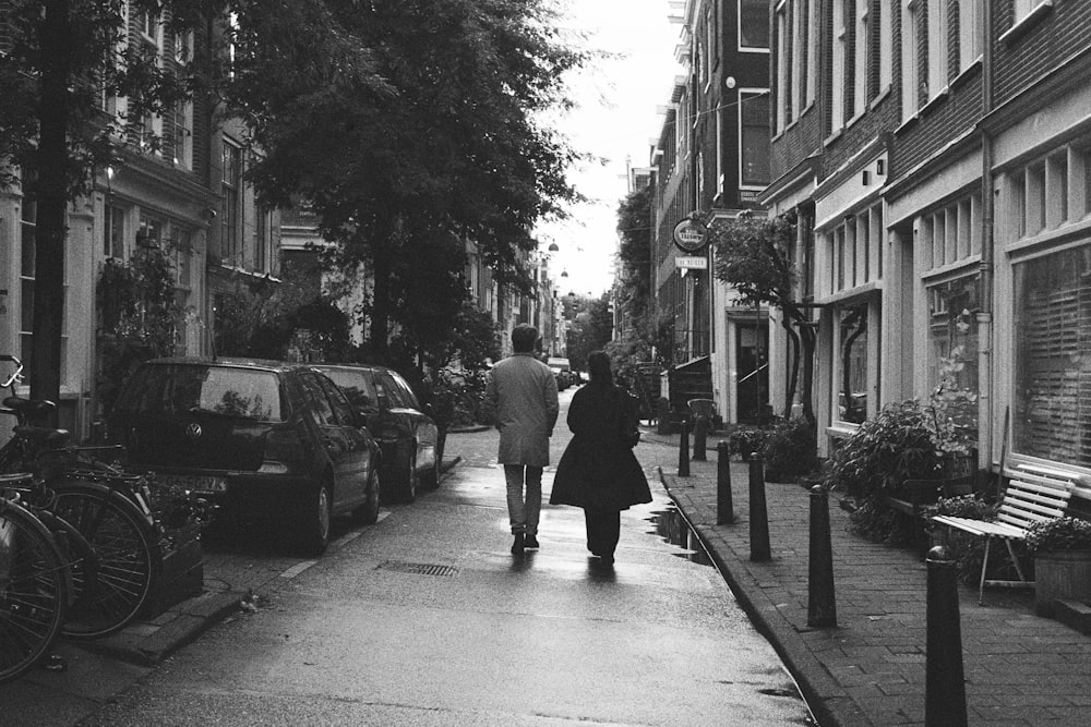 a black and white photo of a man walking down a sidewalk
