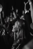 a black and white photo of a woman at a concert