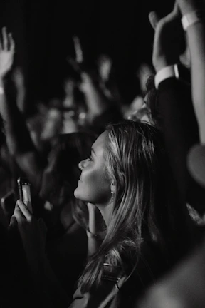 a black and white photo of a woman at a concert