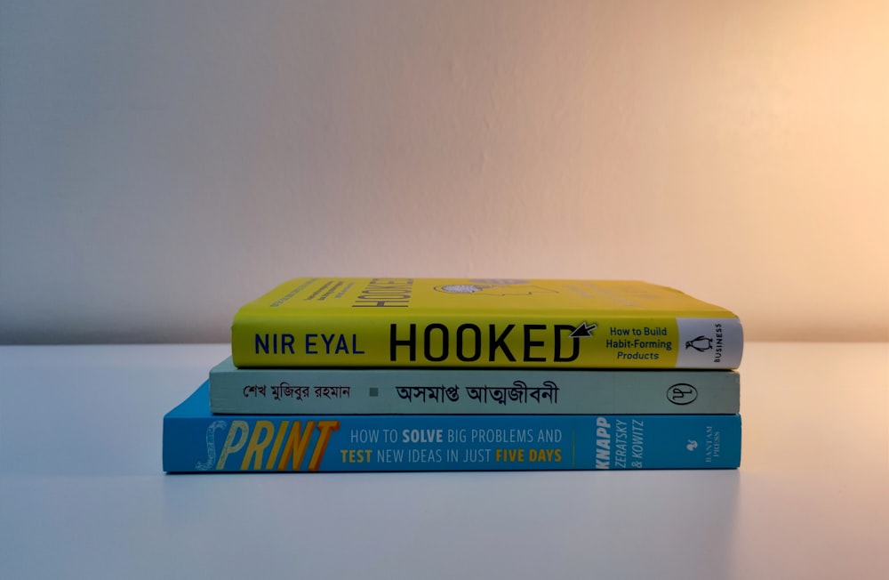 a stack of three books sitting on top of a table