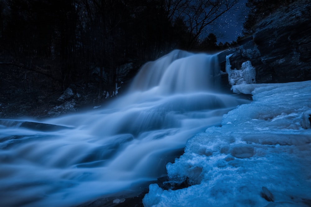 a frozen waterfall in the middle of a forest