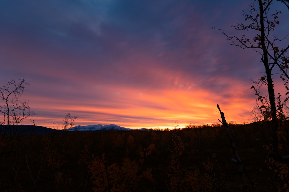 the sun is setting over the mountains in the distance