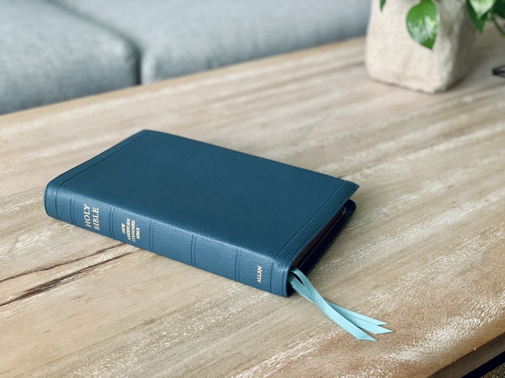 um livro azul sentado em cima de uma mesa de madeira