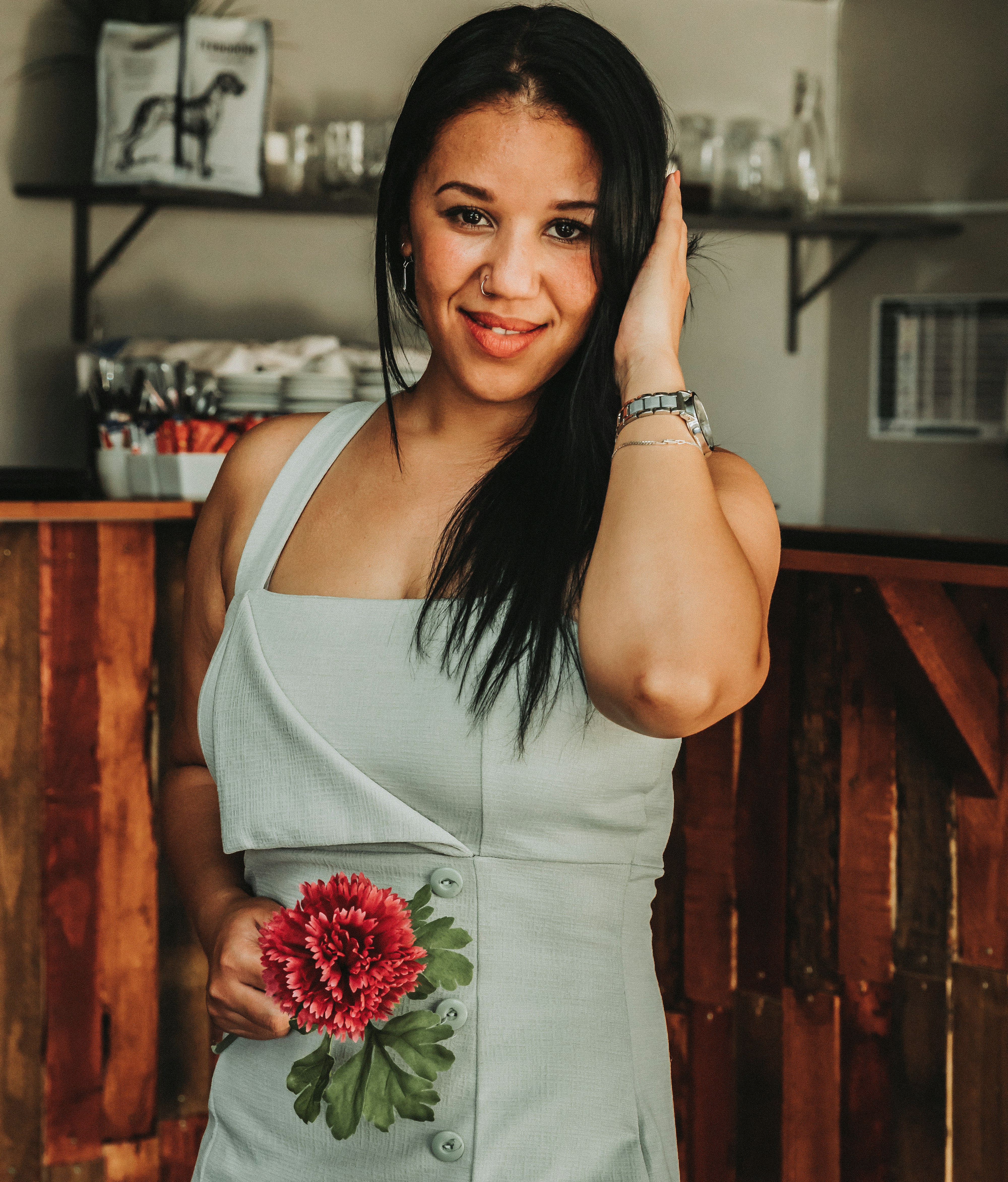 a woman in a gray dress holding a flower