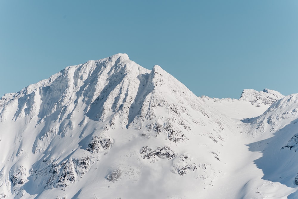 a mountain covered in snow under a blue sky