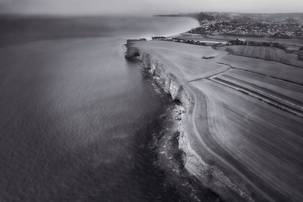 a black and white photo of a beach and ocean