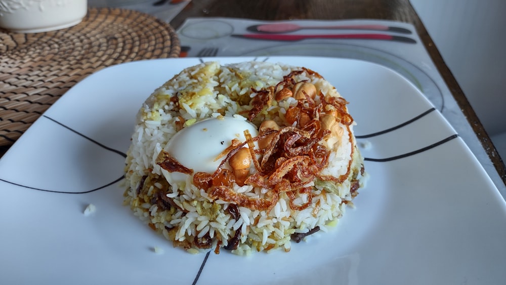 a white plate topped with rice covered in toppings