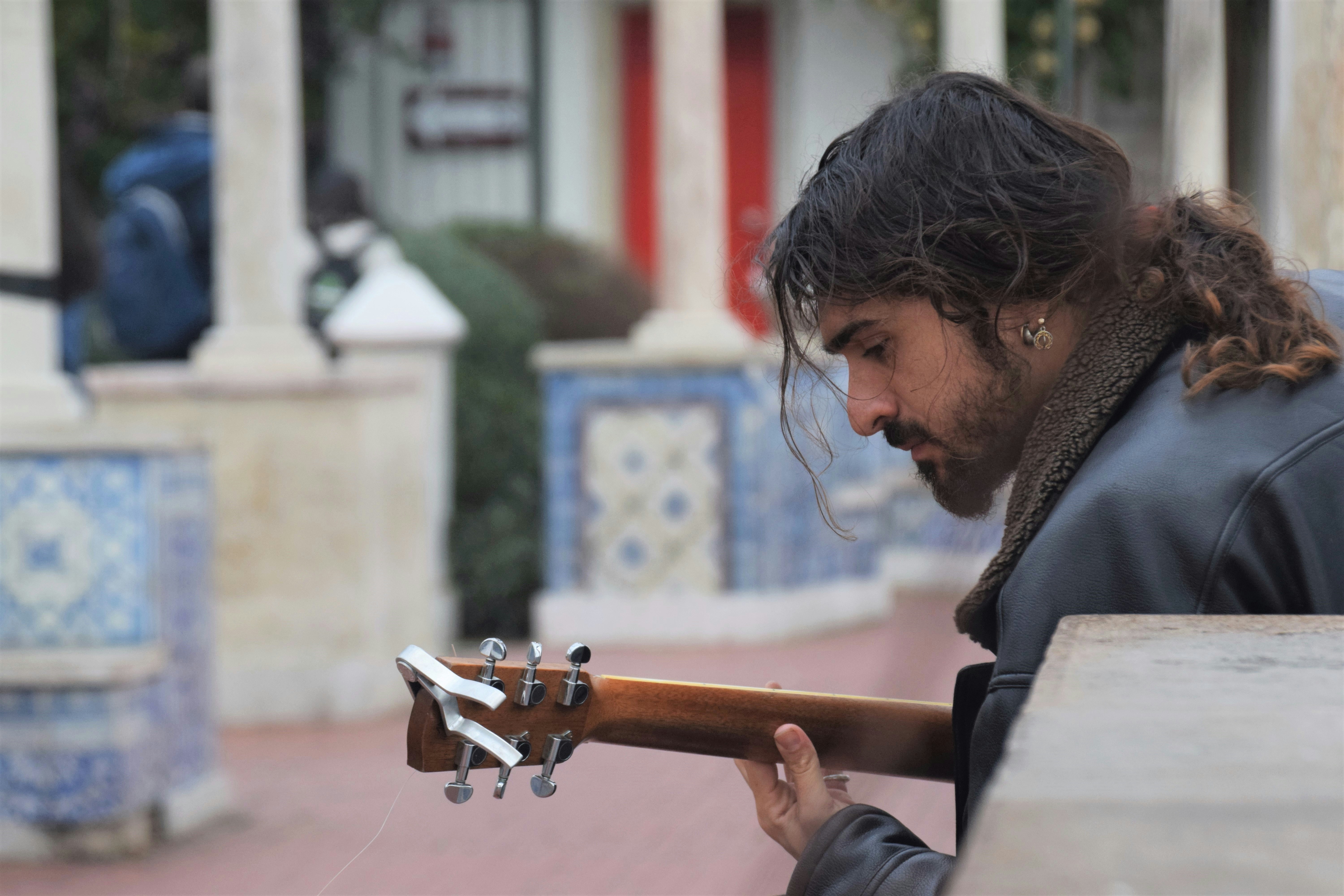 a man with long hair playing a guitar