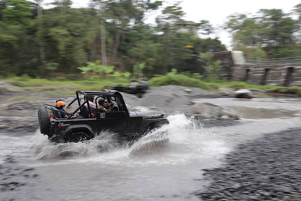 a jeep driving through a river filled with water