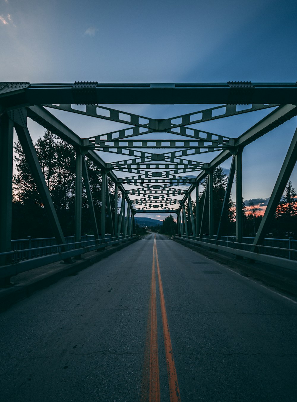 Un camino que cruza un puente con un cielo en el fondo