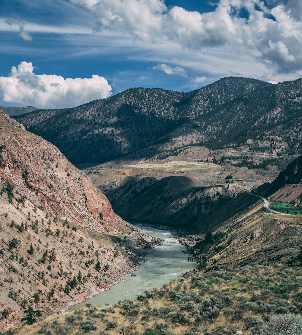 a river running through a valley surrounded by mountains