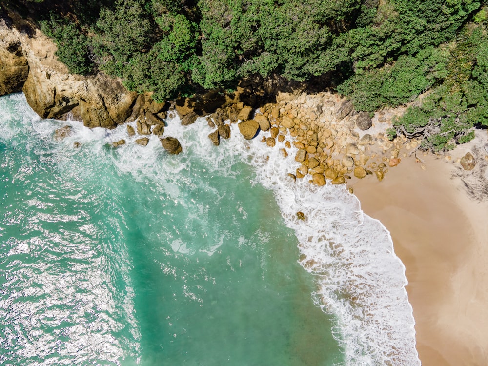 an aerial view of a beach with waves crashing on it