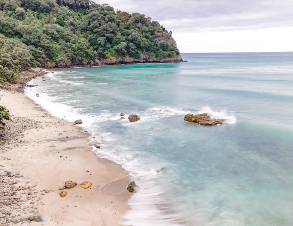 a view of a sandy beach with clear blue water