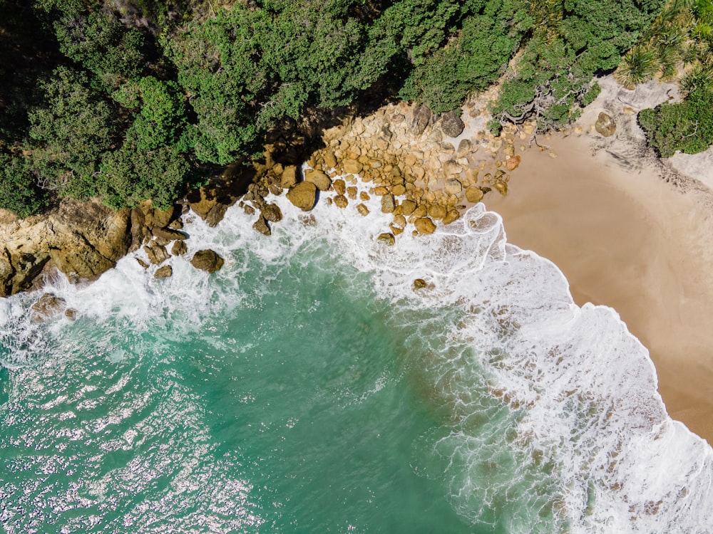 an aerial view of a beach with waves crashing on the shore