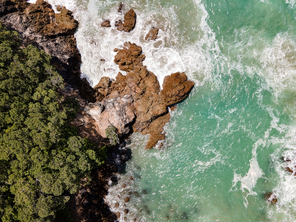 an aerial view of the ocean and rocks