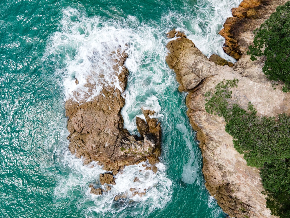 an aerial view of the ocean and rocks