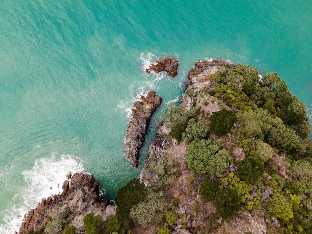 an aerial view of the ocean and rocks