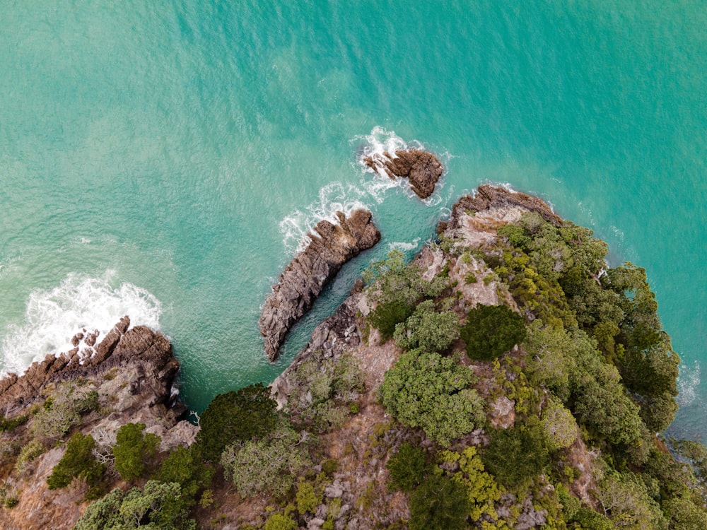 an aerial view of the ocean and rocks