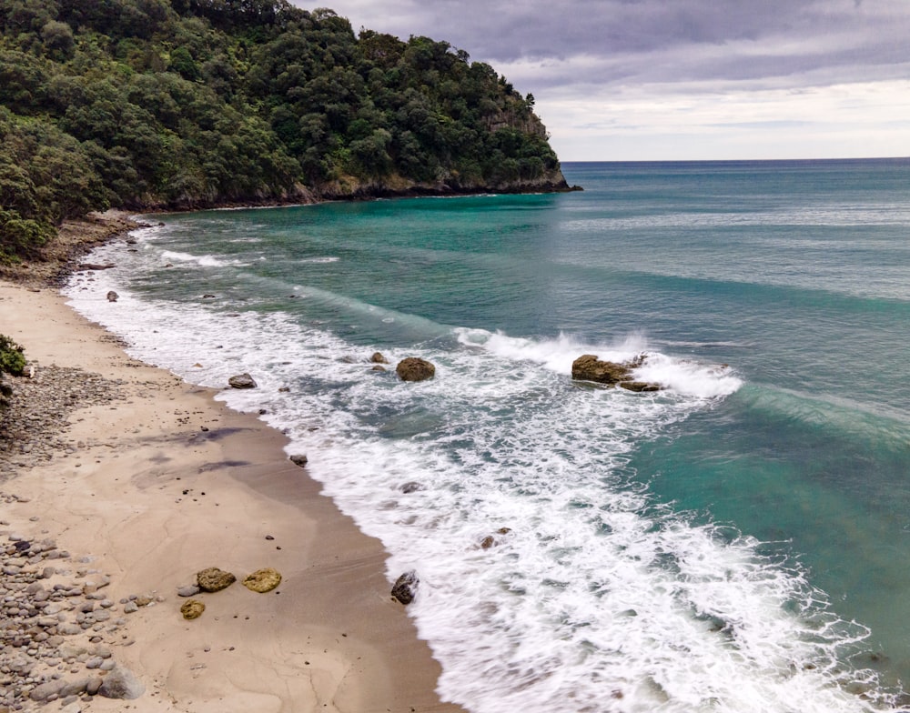 a view of a beach with waves crashing on the shore