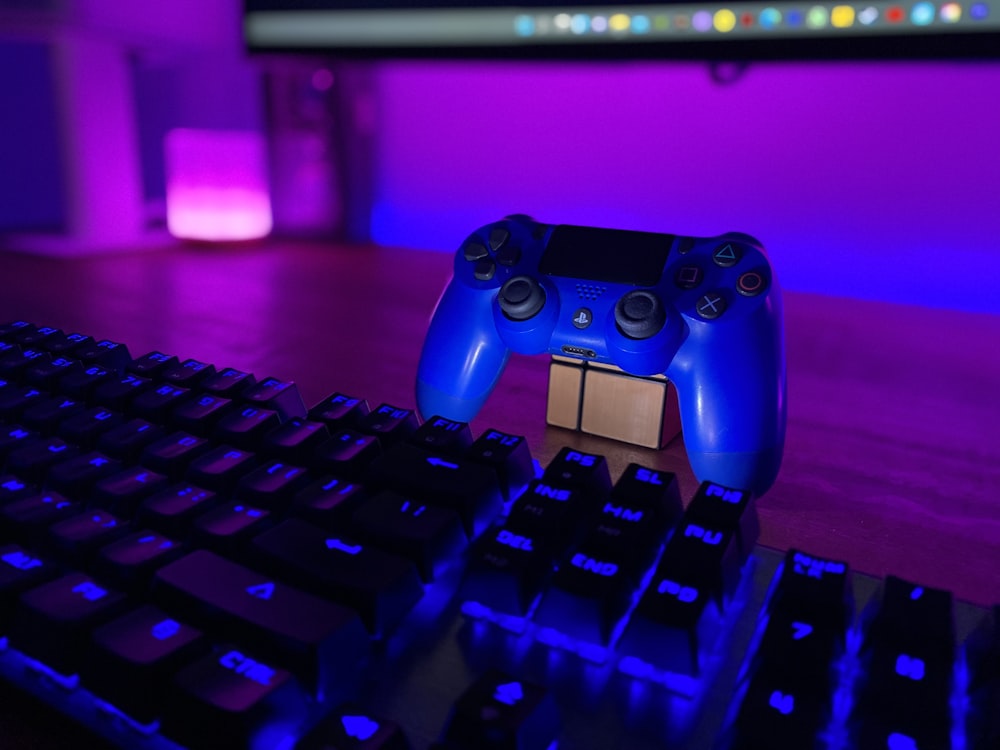 a blue controller sitting on top of a keyboard