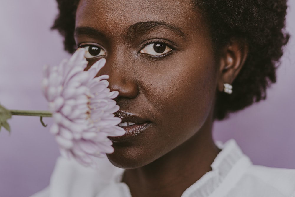 a close up of a person holding a flower