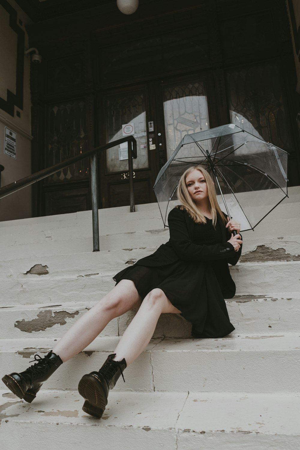 a woman sitting on steps with an umbrella
