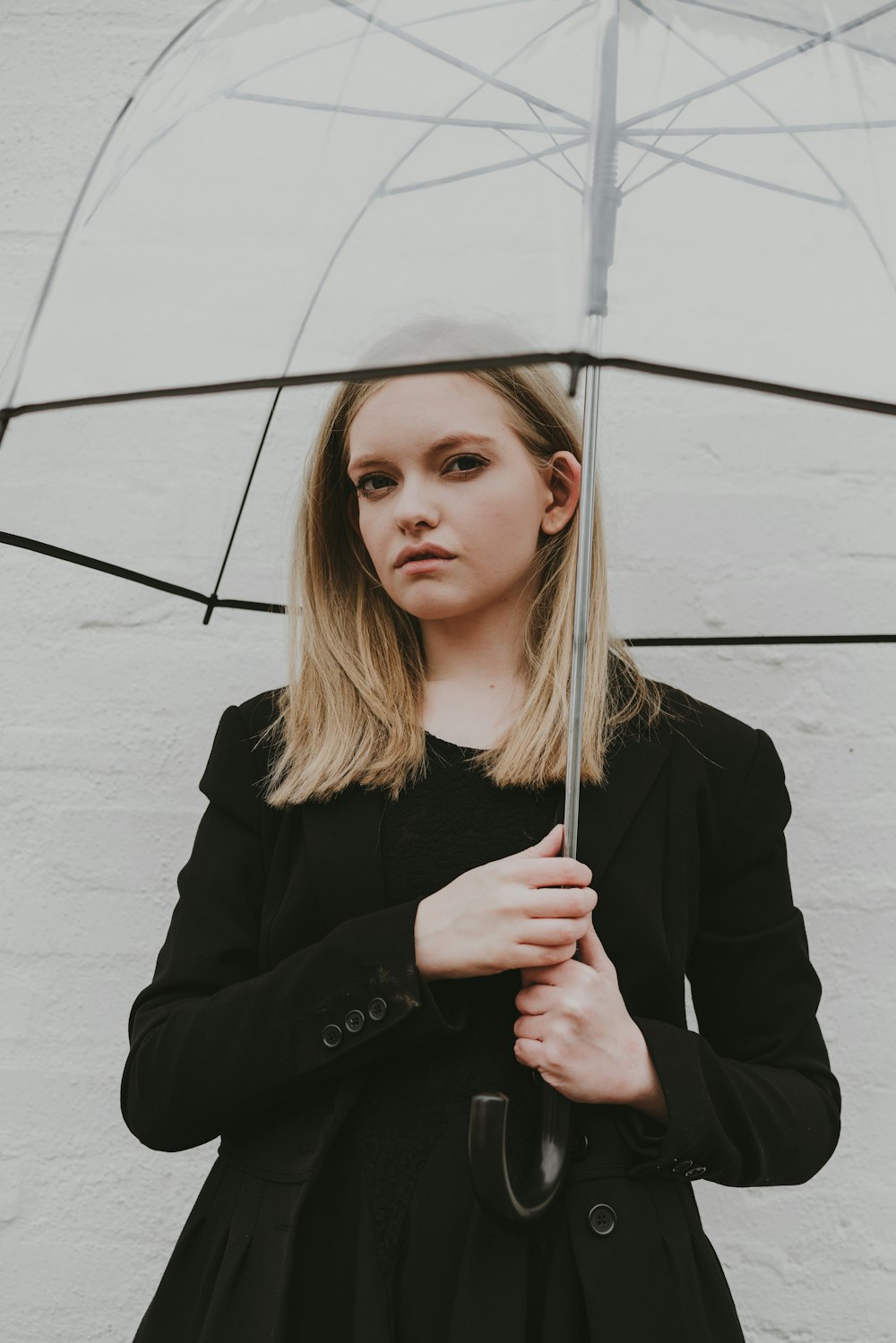 a woman in a black dress holding an umbrella