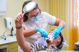 a man getting his teeth checked by a dentist