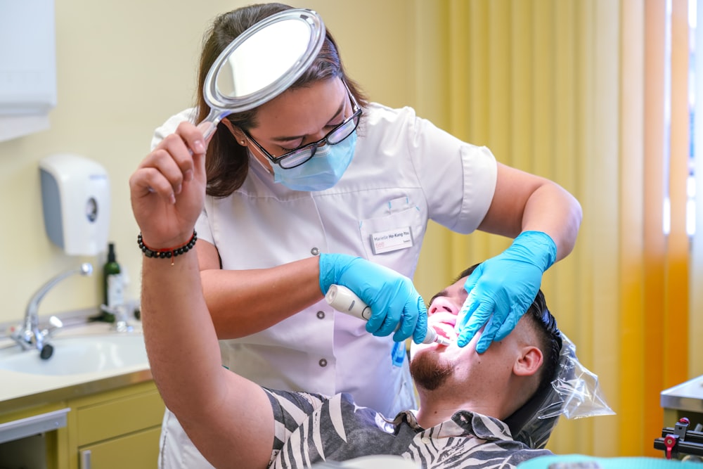 a man getting his teeth checked by a dentist