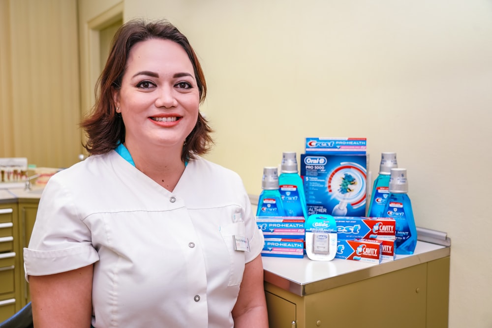 a woman in a dentist's office with toothpaste and toothbrushes